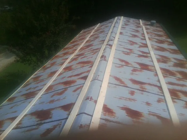 Rusted metal roof panels with new wood purlins before replacement — Storm Damage Roof Repair in Leasburg by Roofing Brothers