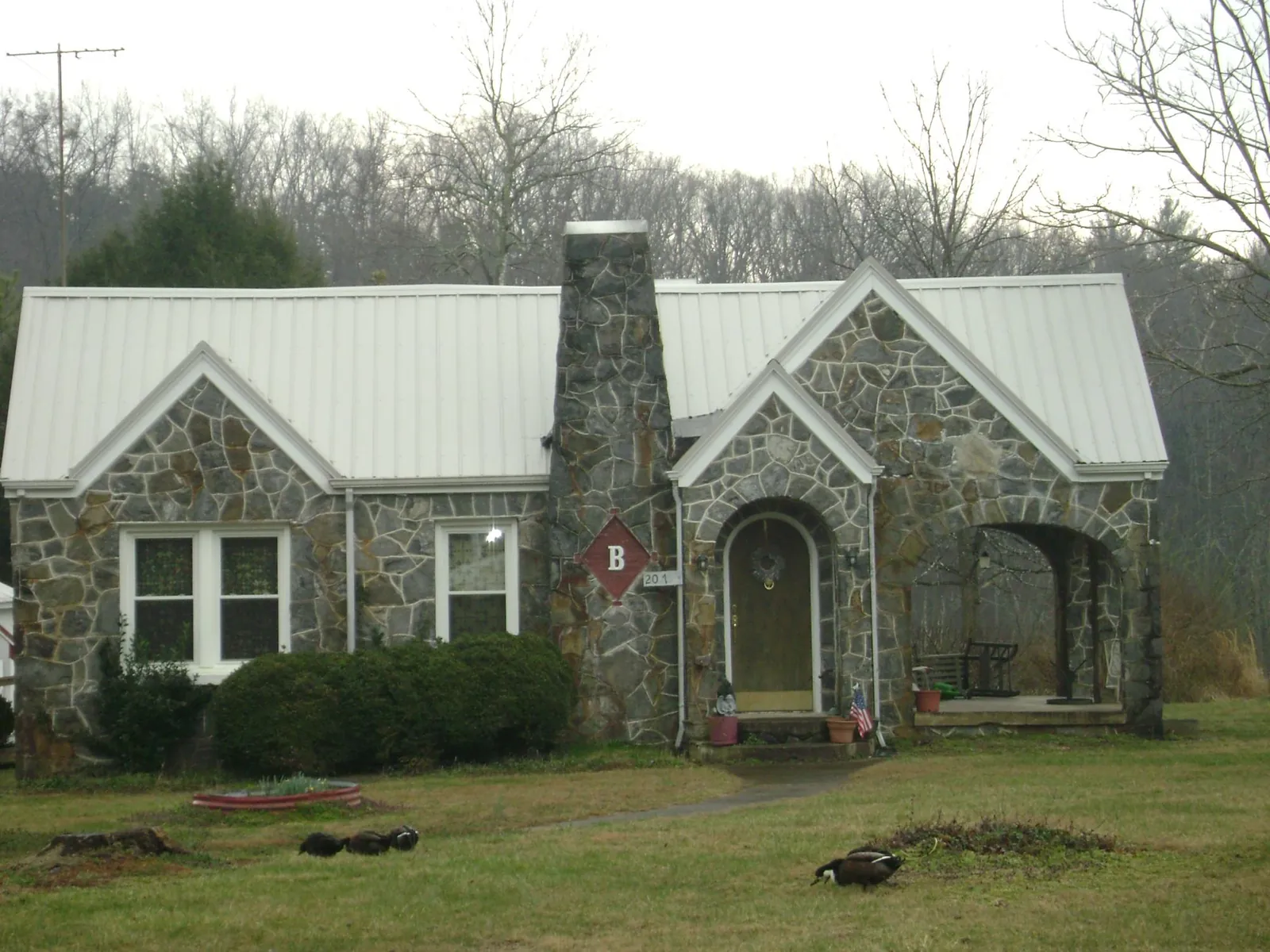White metal roof on a stone cottage with steep gables in Leasburg